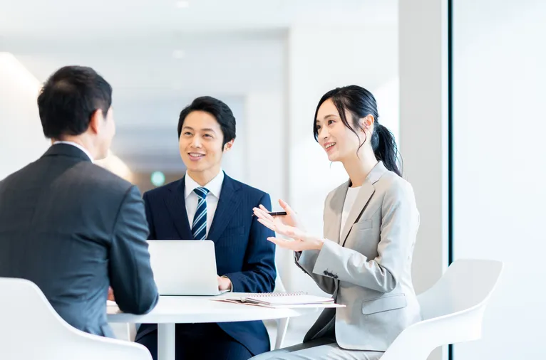 オフィスで打ち合わせをするスーツ姿の3人